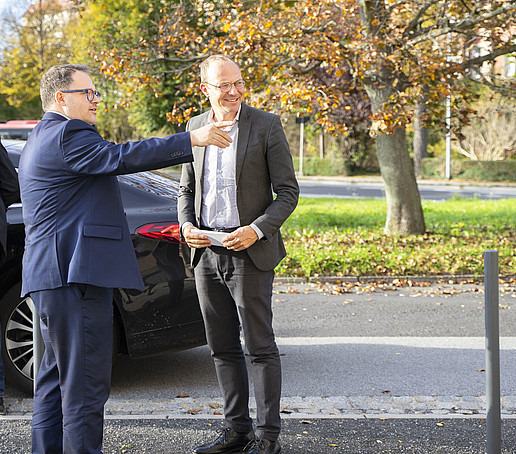 Rektor und Minister am Parkplatz