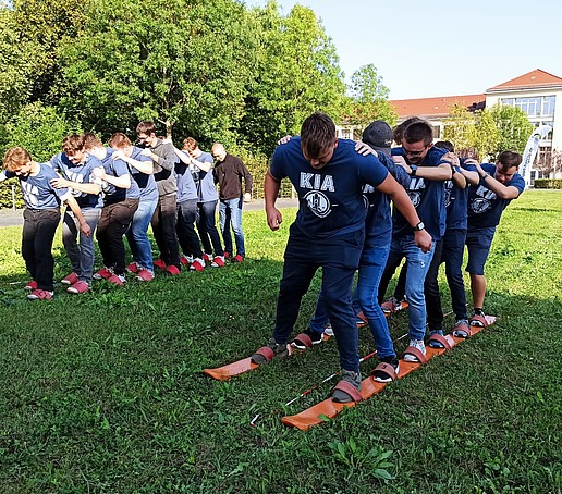 Studierende spielen auf einer Wiese auf dem Campus.