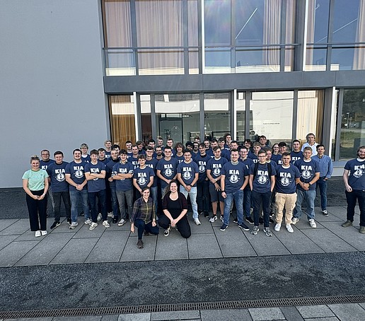 Gruppenbild in KIA-T-Shirts vor dem Campusgebäude.