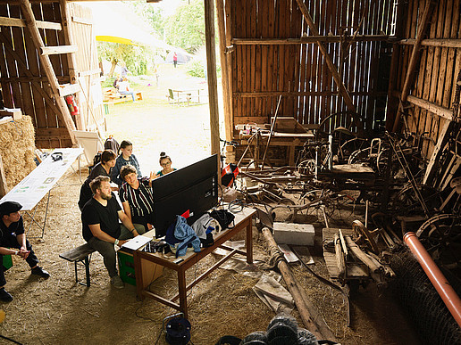 Symbolic image for the citizen science method "land inventory": several people working with modern technology in a barn.