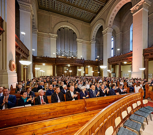 Blick vom Altar auf volle Sitzreihen.