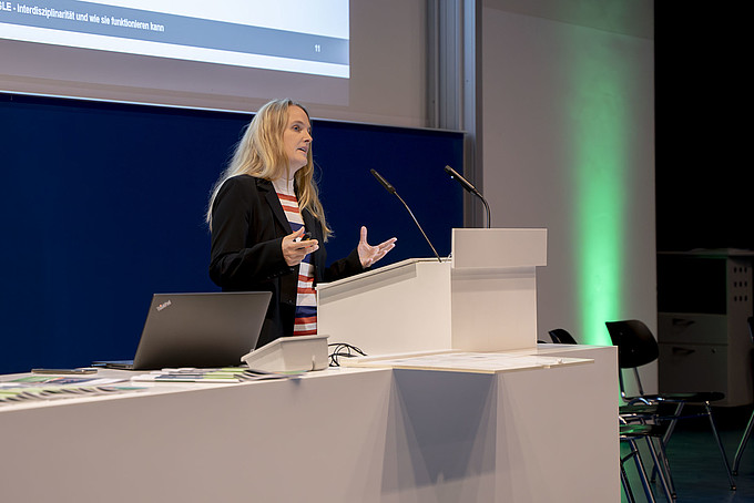 Stefanie Kast stands at a lectern and gives a lecture.