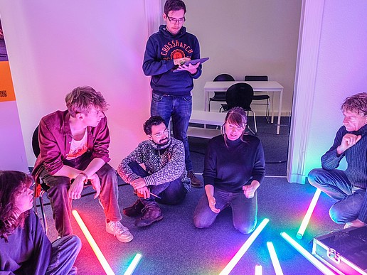 A group of course participants in the seminar room with fluorescent tubes on the floor.