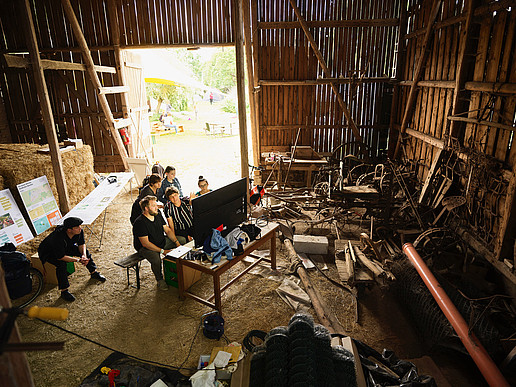 Several people in front of a screen in a barn
