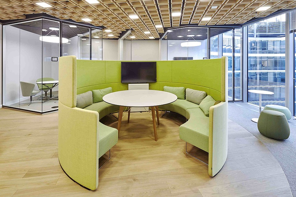 Example of a modern learning space: round table with seat cushions, table and screen