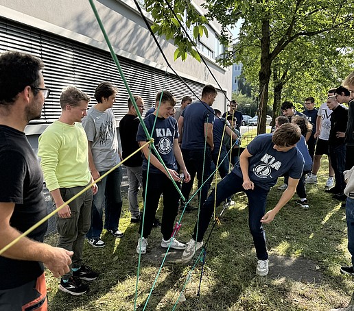 Students play with ropes on a meadow.