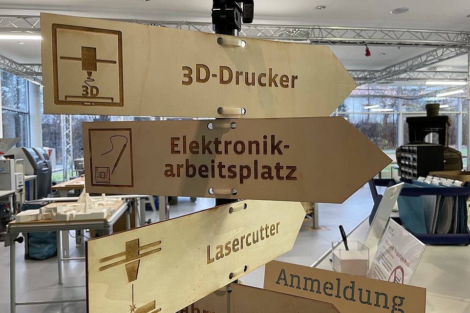 Holzschilder, die die Richtung zum 3D-Drucker und Lasercutter anzeigen.