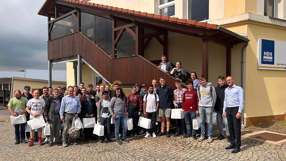 Group photo in front of the MBN company building with participants of the excursion