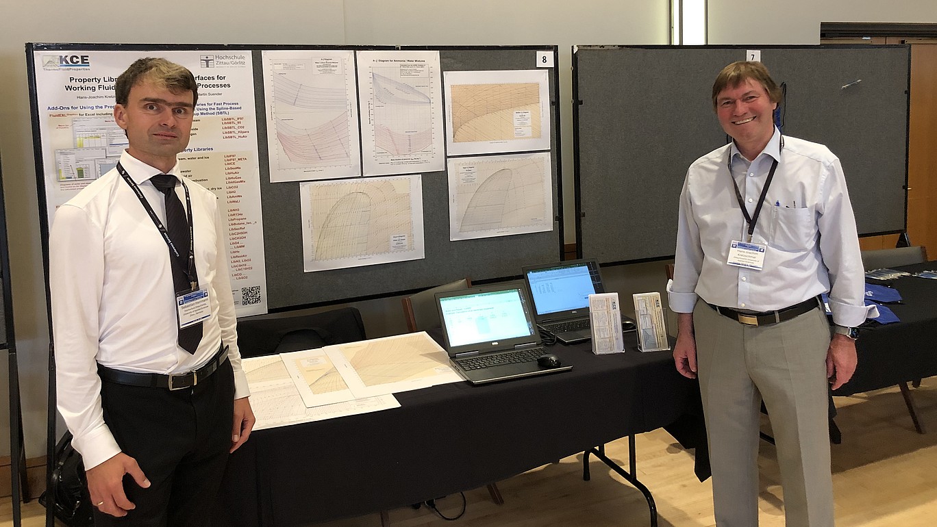 Prof. Kretzschmar (right) and Dr. Herrmann stand in front of a poster presentation.