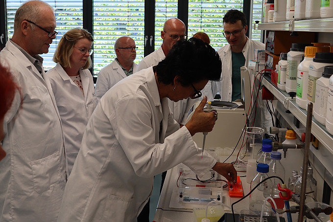 Teachers conduct experiments in a laboratory in white lab coats.