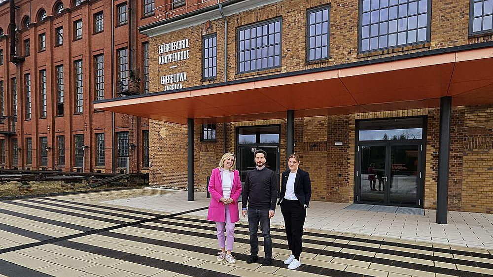 Prof. Sophia Keil, Christian Tiller from the ZukLOS team and the university's KIA representative Kristin Groß (from left to right) in front of the entrance to the Knappenrode energy factory.