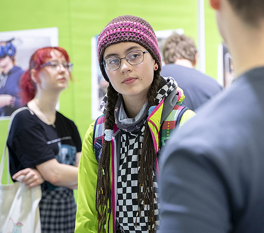 A visitor in a knitted hat looks around the HSZG stand.