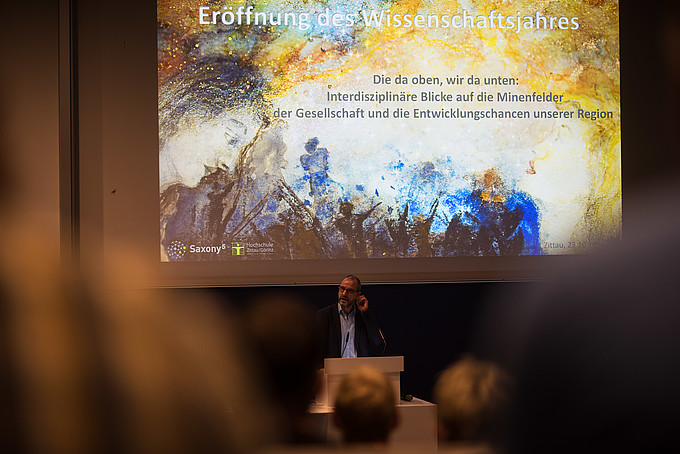 Professor Raj Kollmorgen stands at a lectern and gives a lecture.