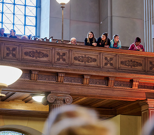 Spectators look into the nave from the gallery.