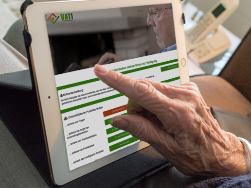 An elderly person's hand moves across the screen of a tablet to find out about assistance technology in home care.
