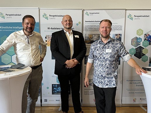 Tino Schmidt, Prof. Matthias Schmidt und David Sauer beim Unternehmerforum Oberlausitz. Sie stehen vor Roll-ups zwischen zwei Stehtischen.