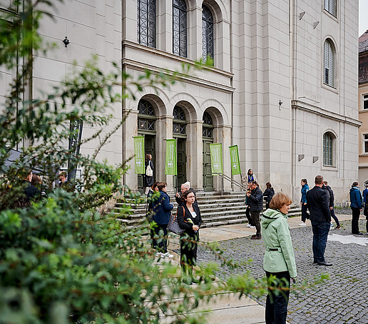 People stand in front of the main entrance to St. John's Church.