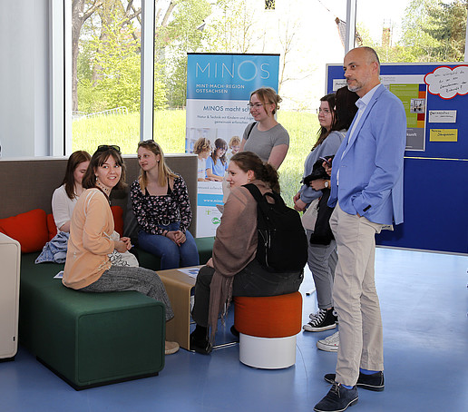 Studierende sitzen in Lounge-Möbeln und besprechen sich.