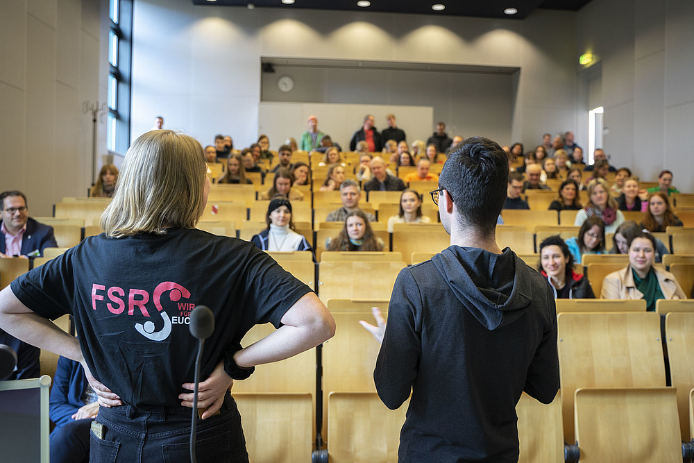Two students, moderator Lennard and Sahra from the Social Sciences student council, stand in front of seated prospective students in the lecture hall and provide information about the courses on offer and campus life at Zittau/Görlitz University of Applied Sciences. The picture shows the open and communicative way in which the university welcomes prospective students and supports them in their decision-making process. It conveys a lively atmosphere and shows how committed and enthusiastic students and staff at the university are about inspiring prospective students to study at Zittau/Görlitz University of Applied Sciences.