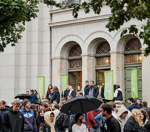 Guests leave the church via the main entrance and open their umbrellas outside.