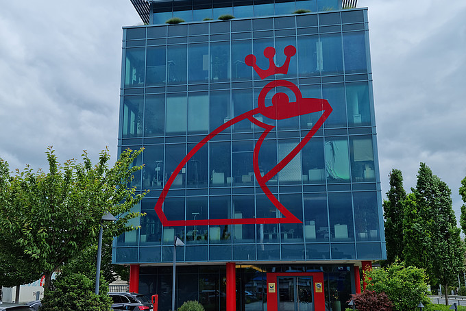 Glass building with red frog façade