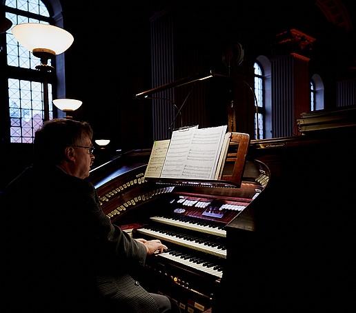 The cantor sits at the organ.