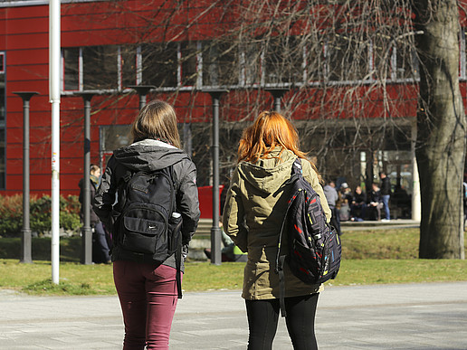 Two students in front of a building of the HSZG