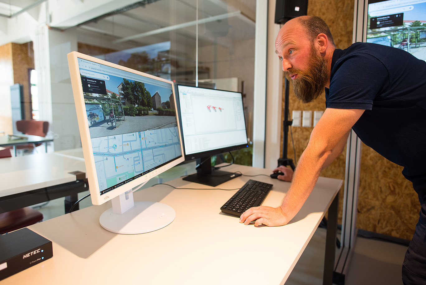 Ein Forschungsmitarbeiter beugt sich über die Tastatur seines Schreibtisches und schaut auf einen Monitor.