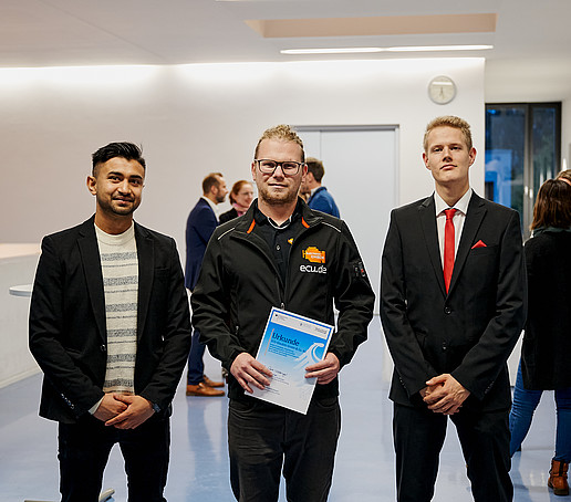 A Germany Scholarship holder holds his certificate in front of him.