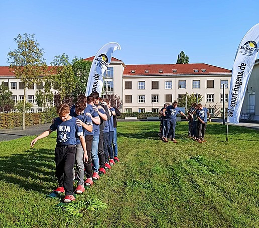 Students play on a meadow on campus.