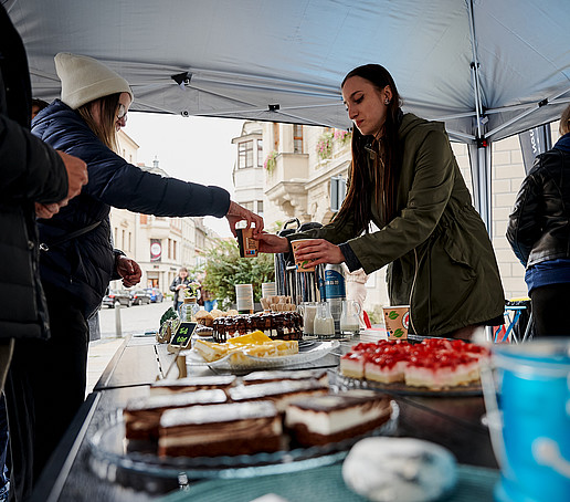 Kaffeestand mit Kuchen vor der Johanniskirche. Gäste werden bedient.