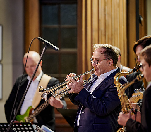 Trumpet and saxophone players play into the microphone.