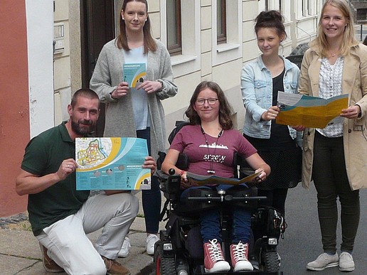 Young people holding a map of Görlitz's old town for people with reduced mobility.