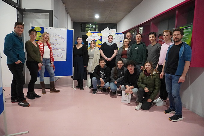 Participants in the Makerspace workshop stand in a room for a group photo.