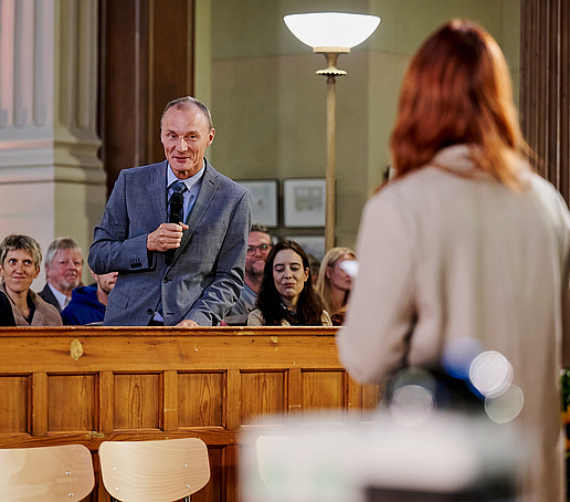 Prof. Wiegert stands and speaks into the microphone.