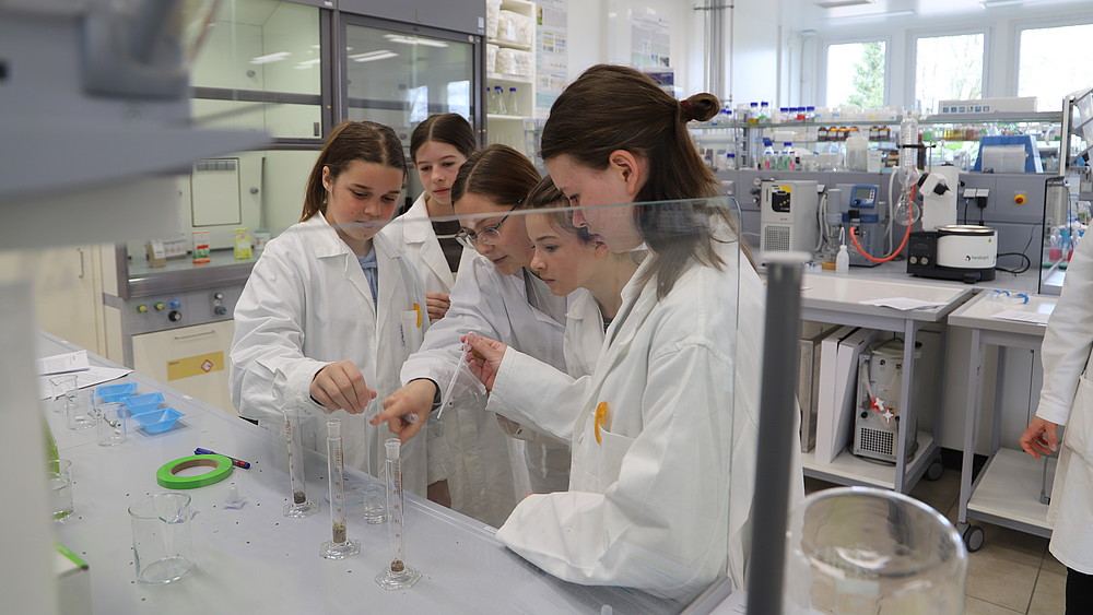 Pupils in the chemistry lab working with measuring beakers.