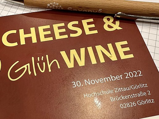 A menu with cheese and mulled wine on it.