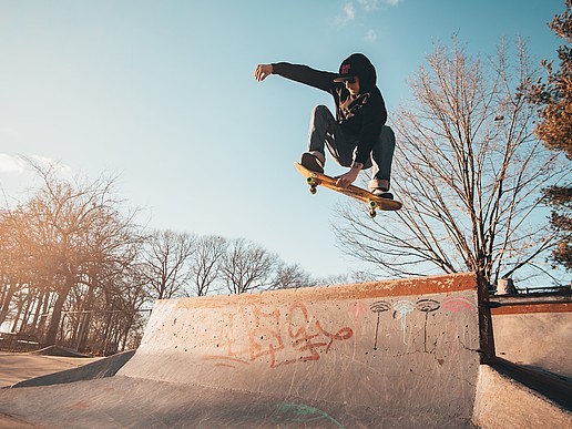A skater flies over a skate park ramp.