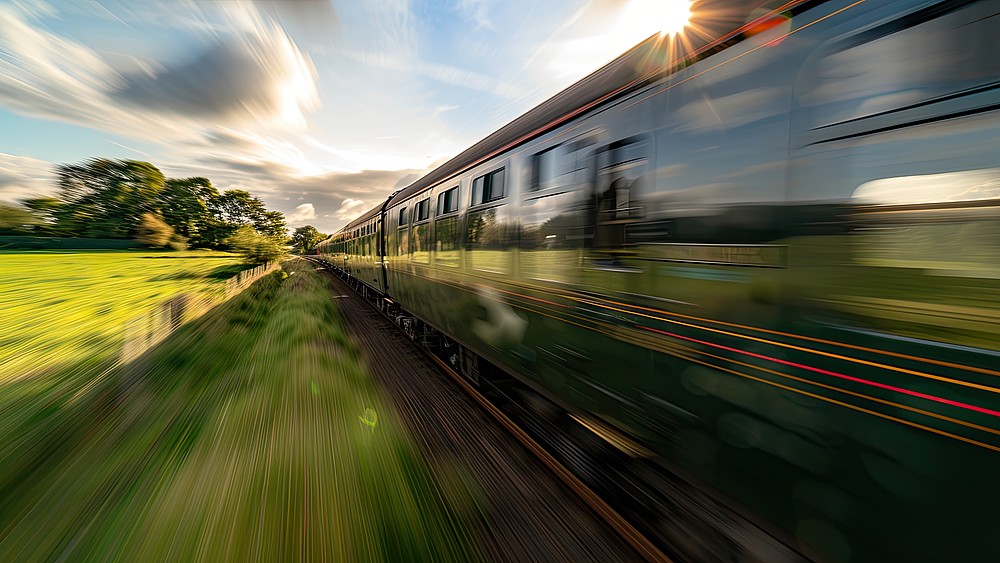 An express train travels through a green landscape