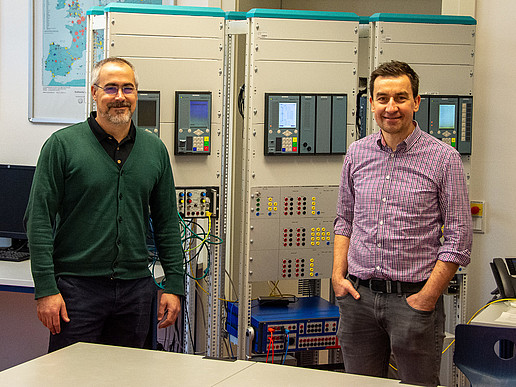 Federico Canas (left) and Prof. Cezary Dzienis (right) commissioning the digital interface with non-conventional converters. In the background are further test benches with digital protection devices (SIPROTEC 5, Siemens AG).