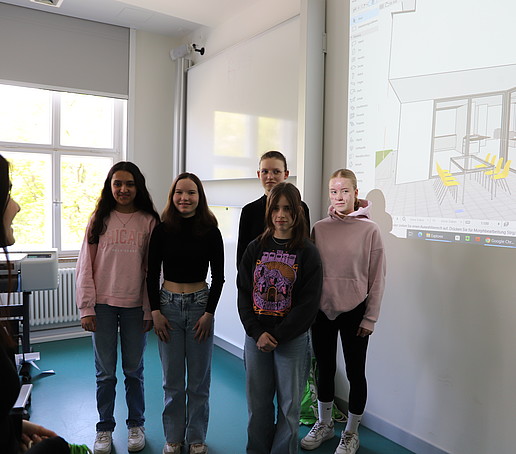 Five schoolgirls stand in front of the projector screen in the CAD lab.
