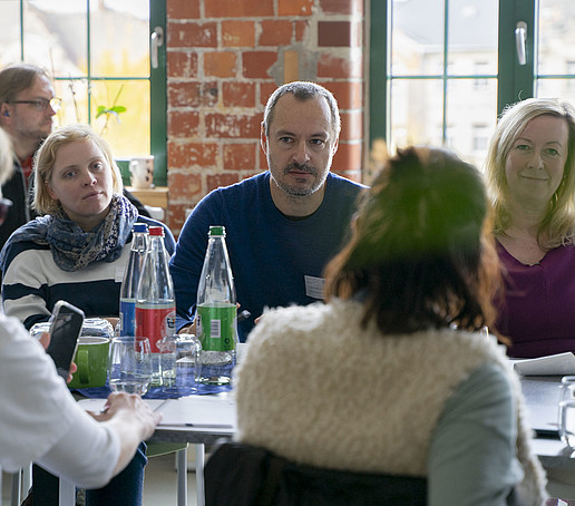 Die Konferenzteilnehmenden sitzen am Tisch.