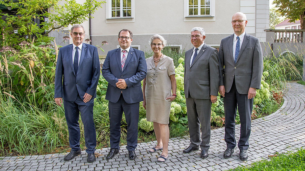 Prof. Uwe Götze, Vice-Rector for Transfer and Continuing Education at Chemnitz University of Technology (l.), Prof. Alexander Kratzsch, Rector of Zittau/Görlitz University of Applied Sciences (2nd from left), Prof. Ursula M. Staudinger, Rector of TU Dresden (center), Prof. Klaus-Dieter Barbknecht, Rector of TU Bergakademie Freiberg (2nd from right) and CircEcon Managing Director Prof. Niels Modler, TU Dresden (r.), met. Klaus-Dieter Barbknecht, Rector of TU Bergakademie Freiberg (2nd from right) and CircEcon Managing Director Prof. Niels Modler, TU Dresden (right), met for the inaugural meeting of the CircEcon Steering Committee on August 16 at TU Dresden. They are standing in the garden in front of a gray building.
