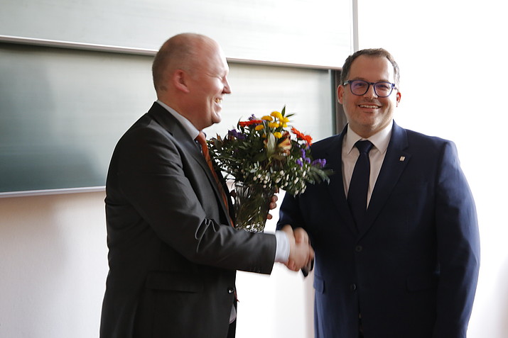 Der Wahlleiter gratuliert Prof. Kratzsch mit einem Blumenstrauß.