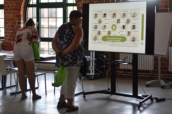 A visitor looks at an employee overview on a digital screen.