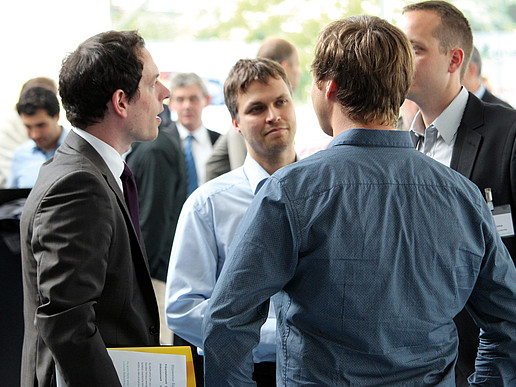 Several men in conversation at a conference
