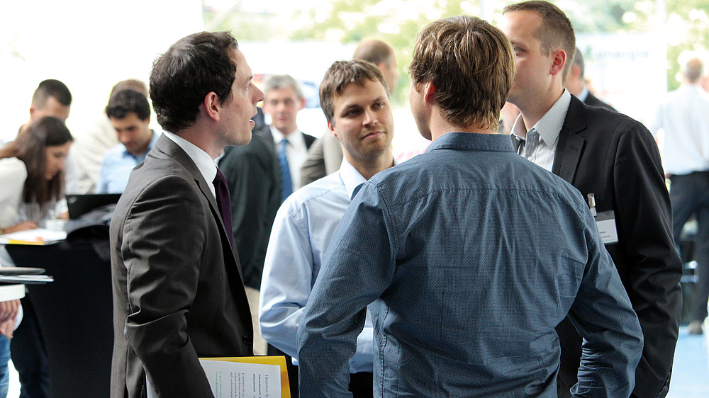 Several men in conversation at a conference
