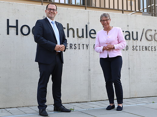 Der Rektor Professor Alexander Kratzsch und die Staatssekretärin Andrea Franke stehen vor dem Schriftzug "Hochschule Zittau/Görlitz"