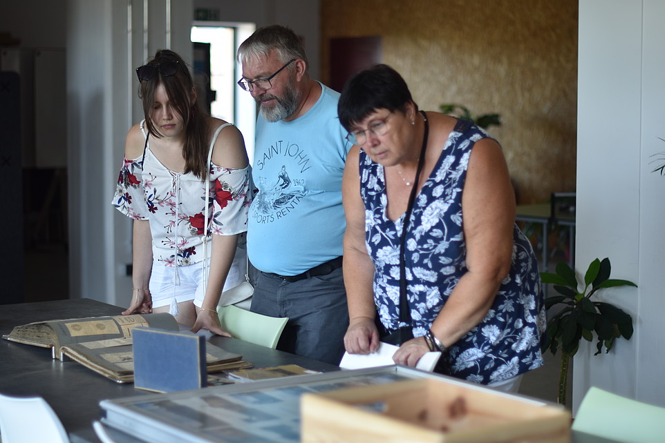 Visitors bend over exhibits lying on a table in Celsiuz.