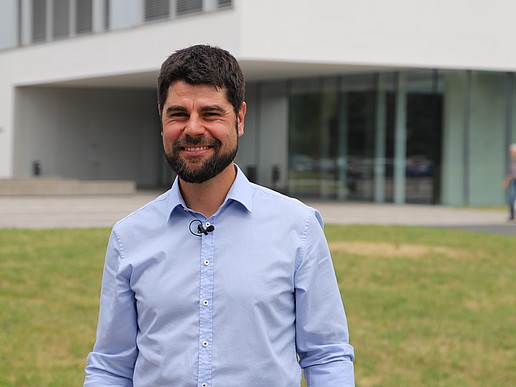 Professor Sebastian Scholz in front of a HSZG building